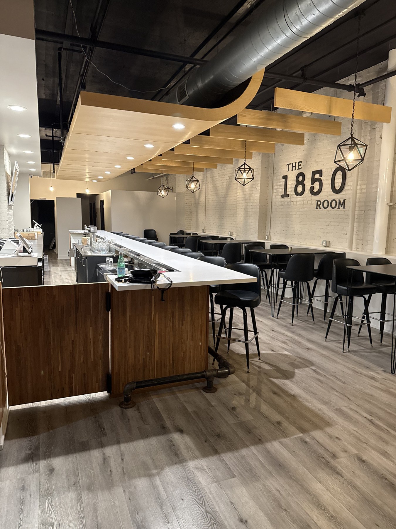 The 1850 Room bar with warm wood, modern lighting and seating